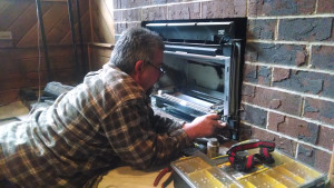 bob inspects and services a gas fireplace